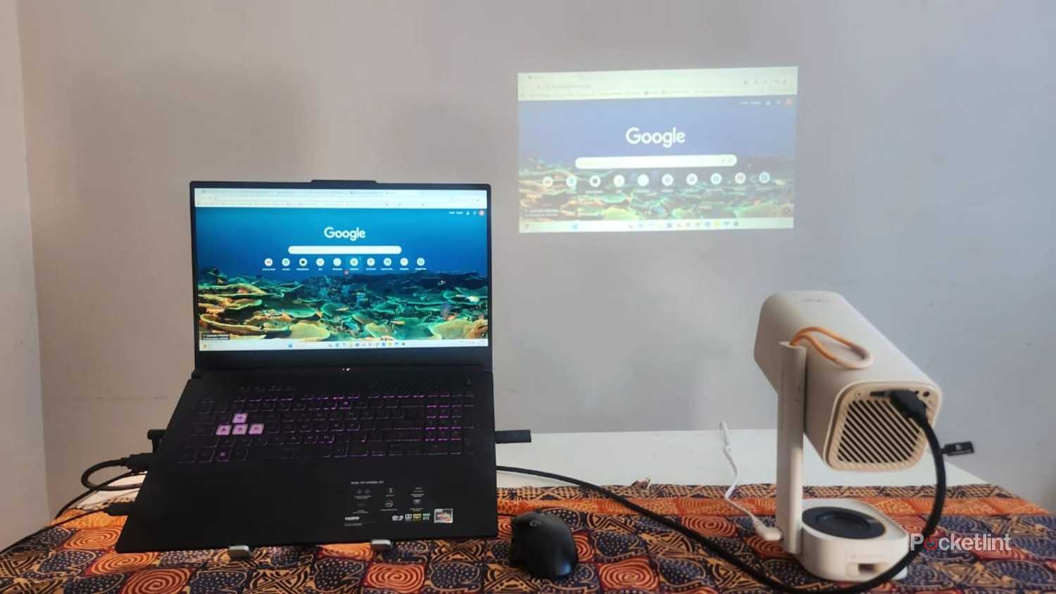 A laptop and projector on a table.