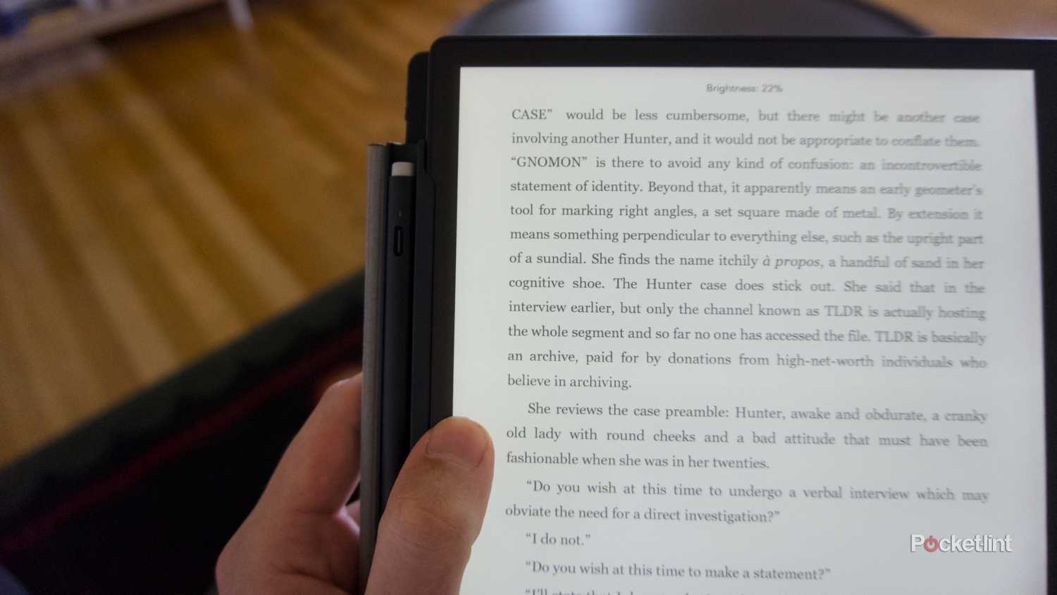 A finger adjusting the brightness on the side of a Kobo Elipsa 2E.