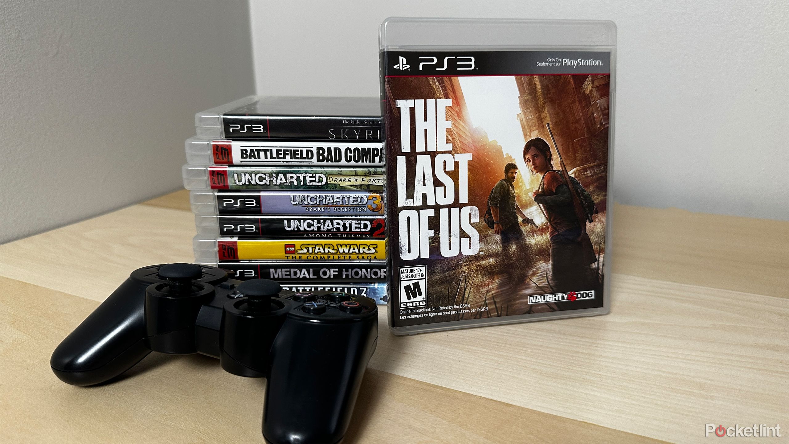 PS3 games next to PS3 controller.